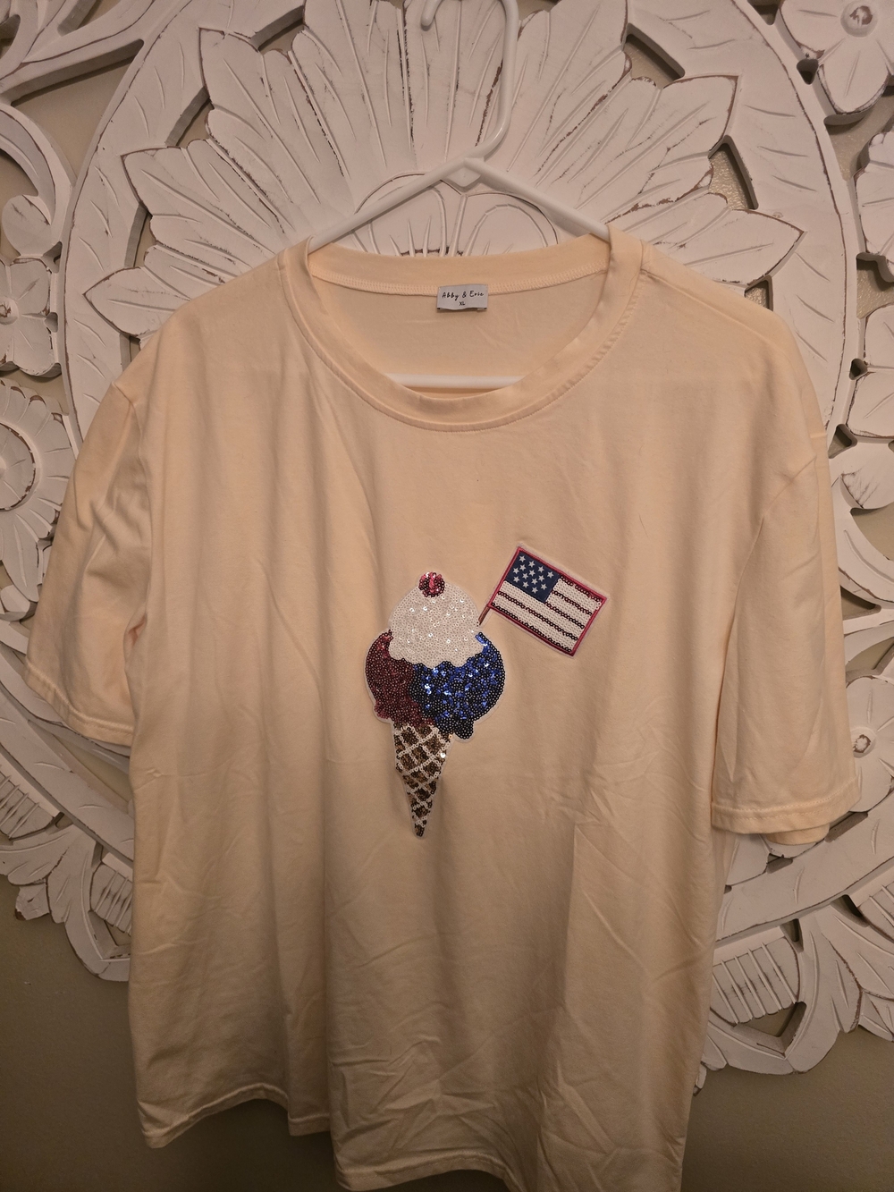 This Abby & Evie ice cream flag sequin top features a playful pale yellow fabric